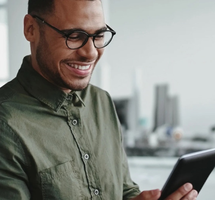 A smiling employee holding a tablet.